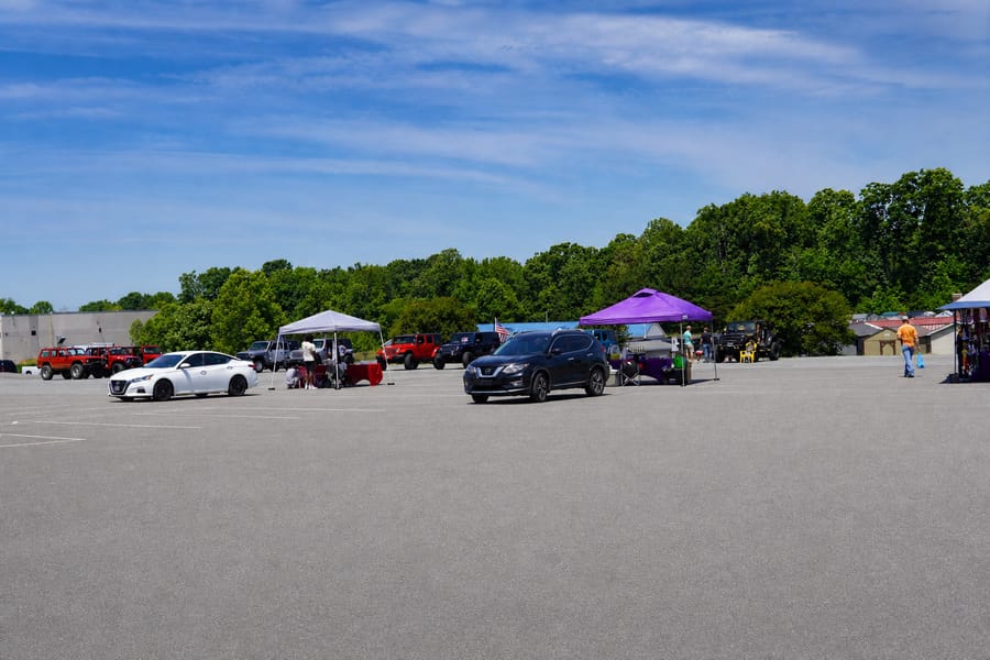 The Jeep Jam crowd parking up at the lot in Mocksville with pop-up tents and food vendors.