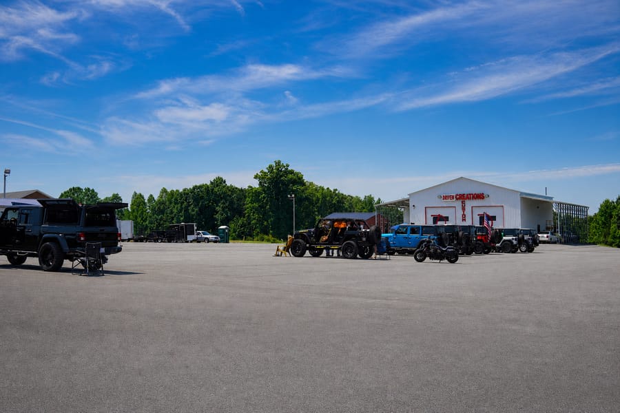 Red Jeep Wrangler rolling past the food trucks and tents at the Jeep Jam.